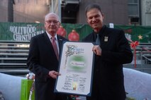 Retired U.S. Marine Corps Lt. Gen. James Laster, president and CEO of the Toys for Tots Foundation, left, presents a certificate of commendation for the city of Los Angeles to Jim Romanovich prior to the start of the 92nd Hollywood Christmas Parade in Hollywood, California, Dec. 1, 2024. The mission of the Toys for Tots Holiday Program is to collect new, unwrapped toys, books, and other gifts and distribute them to less fortunate children at Christmastime. The Hollywood Christmas Parade is an annual American parade held on the Sunday after Thanksgiving in Hollywood; it follows a 3.5-mile route along Hollywood Boulevard, then back along Sunset Boulevard, featuring various celebrities. (U.S. Marine Corps photo by Cpl. Fred Garcia)