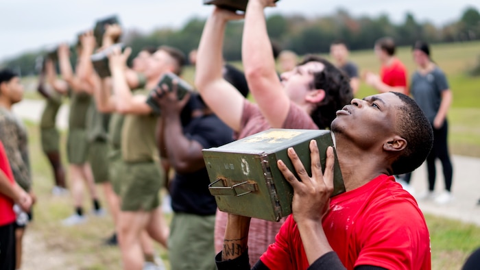 U.S. Marine Corps Poolee Emmanuel Bingham, foreground, with Recruiting Sub Station Beaumont, Recruiting Station Houston, executes an ammo can lift during an initial strength test at Gulf Terrace Park in Beaumont, Texas, Dec. 14, 2024. Poolees with RSS Beaumont were evaluated on their pull-ups, ammo can lifts, plank, and 1.5-mile run in order to prepare them for recruit training. (U.S. Marine Corps photo by Sgt. Ryan H. Pulliam)