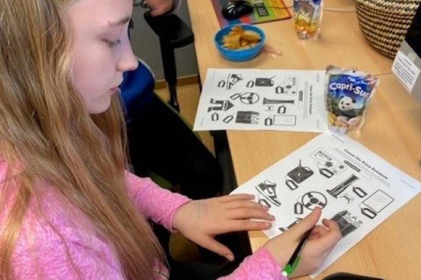 A young child works on a worksheet.