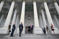 A group of soldiers and civilians stand outside of the U.S. Capitol discussing plans for the pass in review.