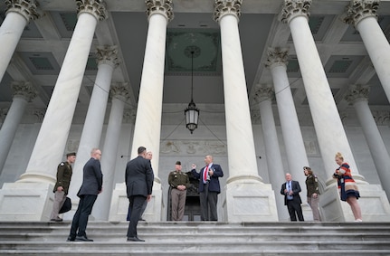 A group of soldiers and civilians stand outside of the U.S. Capitol discussing plans for the pass in review.