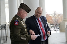 A soldier and a civilian discuss plans for the pass in review at the Capitol