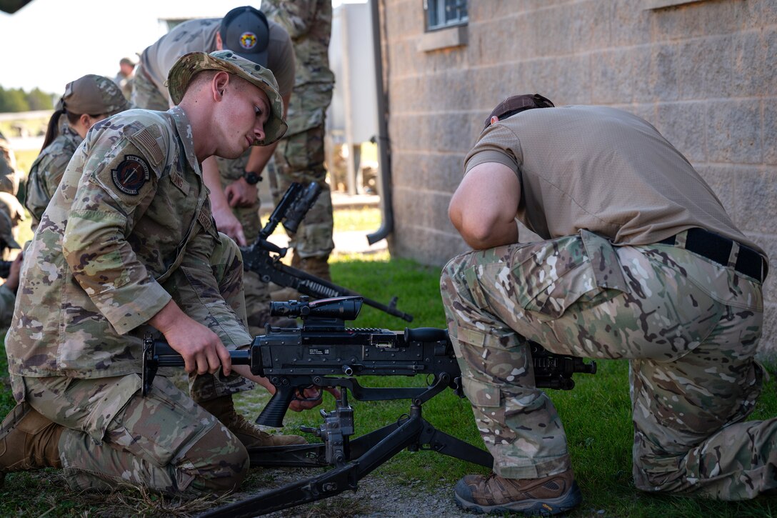 Airman 1st Class Oskar Stang, left, Security Forces Squadron, 171st Air Refueling Wing, Pennsylvania National Guard, practices loading and clearing an M240 machine gun alongside a U.S. Soldier assigned to the 2nd Battalion, 5th Special Forces Group (Airborne), during exercise Sage Eagle 25-1 at Saint Vith Range on Fort Knox, Kentucky, Oct. 20, 2024. Exercise Sage Eagle is a recurring, battalion-sized, unconventional warfare exercise that validates Special Forces’ ability to operate in uncertain environments while training and incorporating partner forces into an evolving contested environment. (U.S. Air National Guard photo by Tech. Sgt. Sarah M. McClanahan)