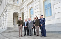 A group of Soldiers, Airmen and civilians standing outside next to the U.S. Capitol.