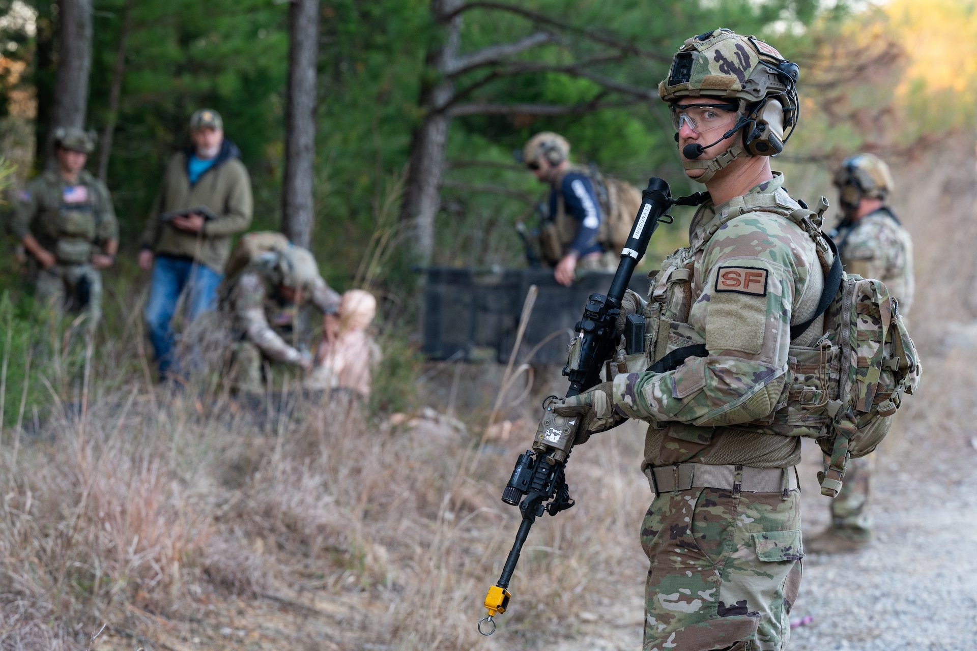 Staff Sgt. Michael Insogna, front right, assigned to the Security Forces Squadron, 106th Airlift Wing, New York National Guard, stands guard while a U.S. Soldier assigned to the 2nd Battalion, 5th Special Forces Group (Airborne), administers aid to a simulated victim of an improvised explosive device blast at Fort Knox, Kentucky, Oct. 23, 2024. This training was a component of exercise Sage Eagle 25-1, a recurring, battalion-sized, unconventional warfare exercise that validates Special Forces’ ability to operate in uncertain environments while training and incorporating conventional forces into an evolving contested environment. (U.S. Air National Guard photo by Tech. Sgt. Sarah M. McClanahan)