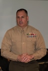 Service members and civilians gather around a conference table talking