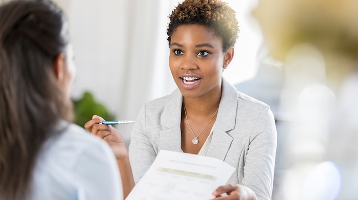 A black NSA HR employee going over a job offer from NSA with a female job candidate