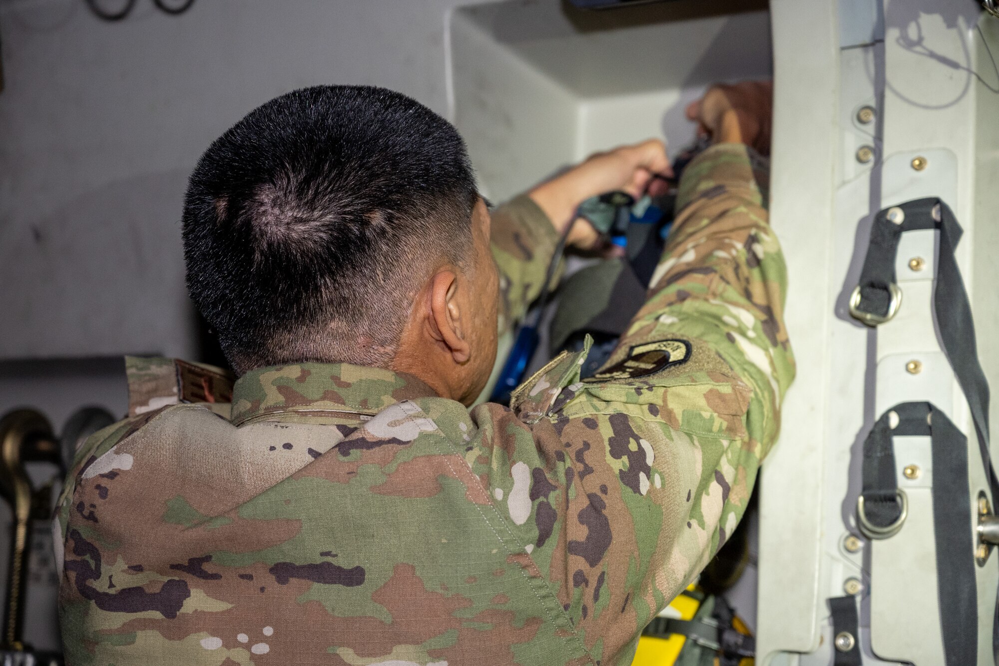 U.S. Air Force Senior Airman Brysen Palaroan, 62d Operations Support Squadron aircrew flight equipment technician, demonstrates configuring a quick don mask on a C-17 Globemaster III at Joint Base Lewis-McChord, Washington, Dec. 10, 2024.