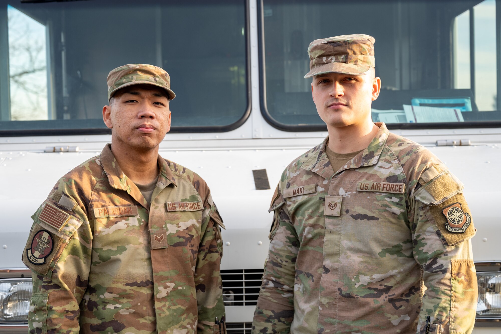 U.S. Air Force Senior Airman Brysen Palaroan, left, and Staff Sgt. Spencer Maki, both 62d Operations Support Squadron aircrew flight equipment technicians, stand in front of a utility truck at Joint Base Lewis-McChord, Washington, Dec. 10, 2024.