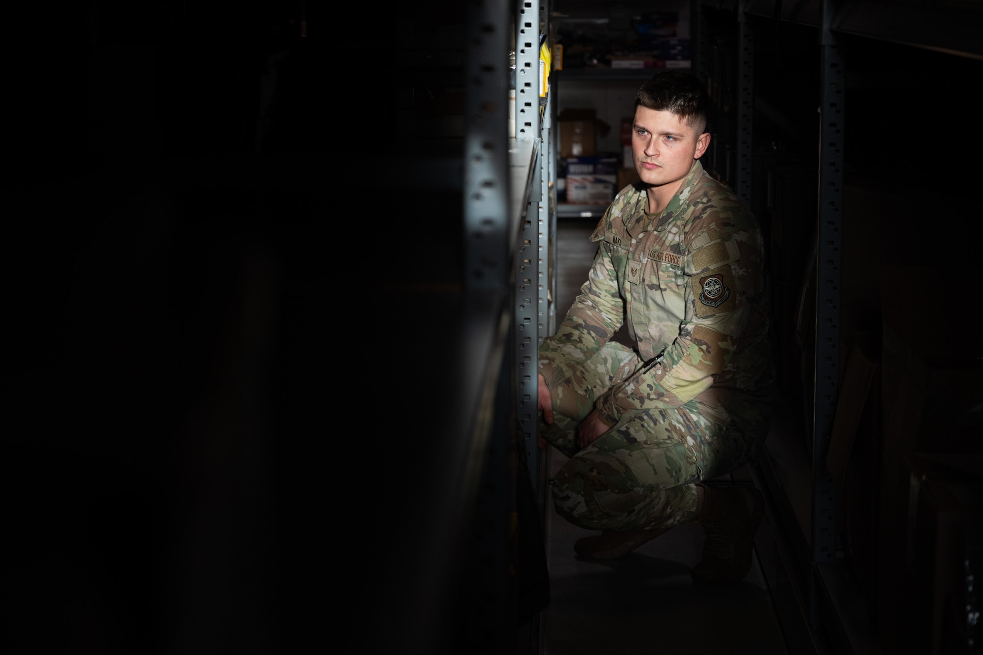 U.S. Air Force Staff Sgt. Spencer Maki, 62d Operations Support Squadron aircrew flight equipment technician, searches the AFE warehouse shelves for equipment at Joint Base Lewis-McChord, Washington, Dec. 10, 2024.