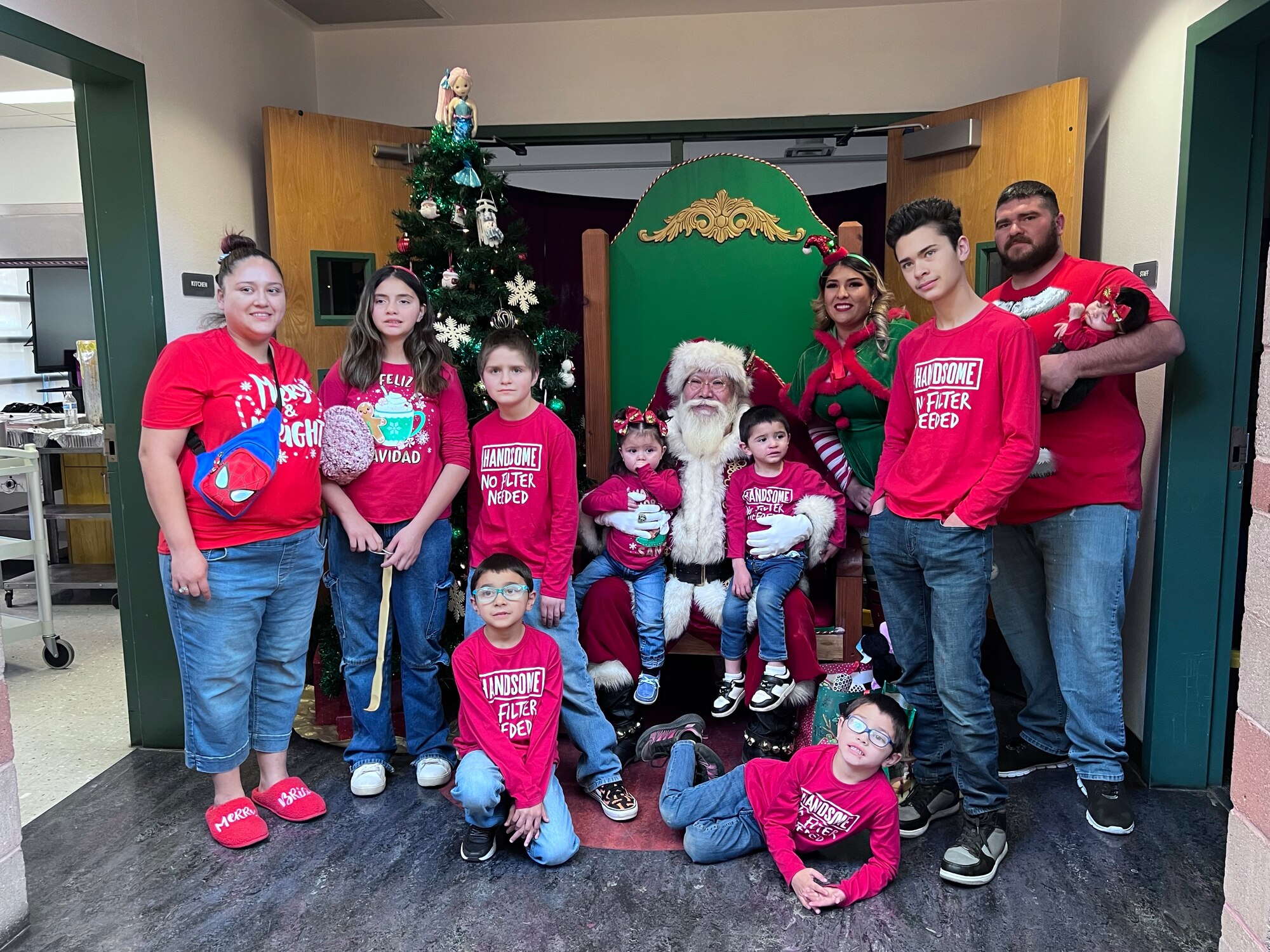 Families in red shirts pose for a photo with santa