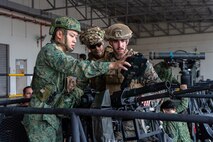 U.S. Marines with 2nd Battalion, 7th Marine Regiment, attached to Marine Rotational Force-Southeast Asia, alongside Singapore Guardsmen with 7th Singapore Infantry Brigade, conduct a weapons exchange subject matter expert exchange during Valiant Mark 24 on Pasir Laba Camp, Singapore, Dec. 10, 2024. Valiant Mark is an annual, bilateral training exercise conducted between the Singapore Armed Forces and I MEF, designed to enhance interoperability, improve combined arms and amphibious warfighting skills, and strengthen military-to-military relationships. MRF-SEA is a rotational unit derived from elements of I MEF executing a U.S. Marine Corps Forces, Pacific operational model that involves training events and exchanges with partner military subject matter experts, promotes security goals with Allied and partner nations, and ensures a persistent I MEF stand-in presence west of the International Date Line. (Courtesy asset of the Singapore Armed Forces)