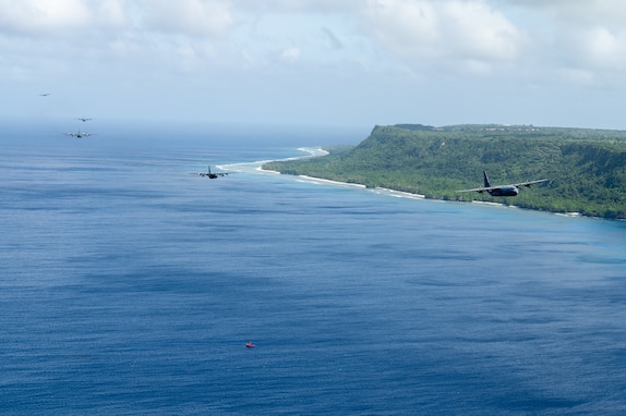 A formation of C-130J Super Hercules and C-130H Hercules aircraft fly together near the coast of Guam, Dec. 14, 2024, to culminate Operation Christmas Drop 2024.