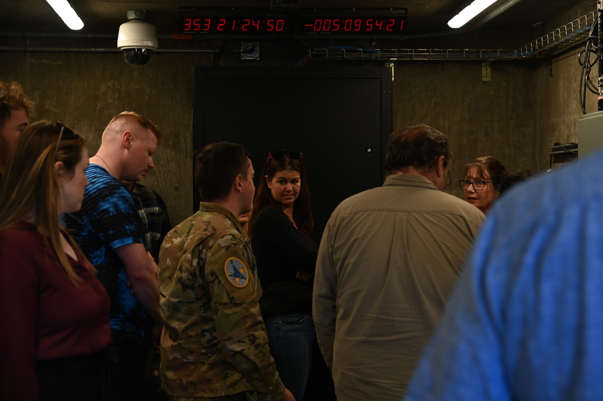 people walking around different areas of a launch facility, metal tower involved, rooms with wires and buttons as well.