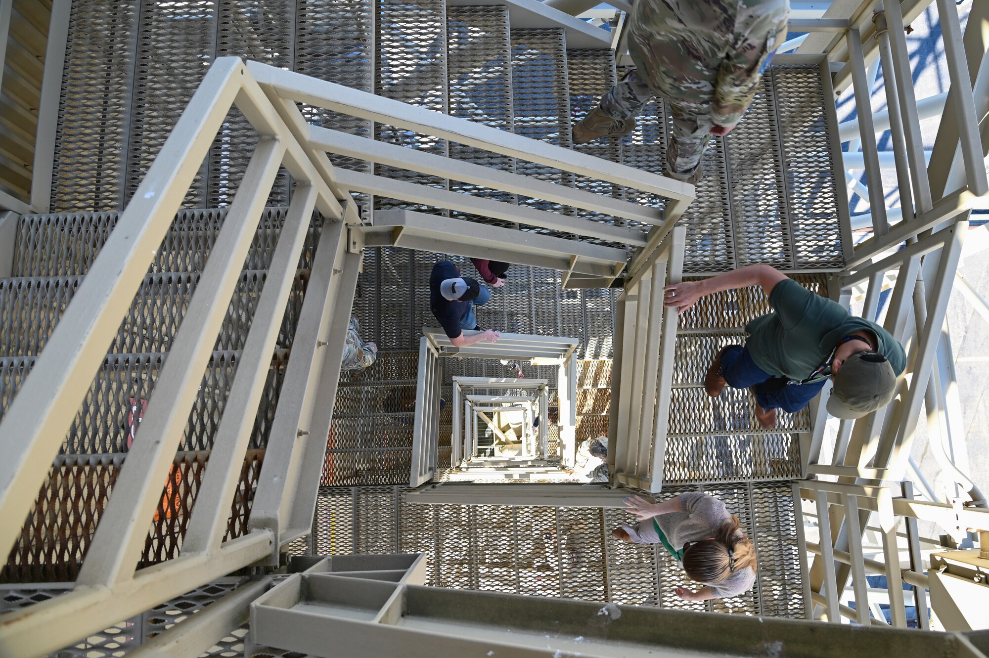 people walking around different areas of a launch facility, metal tower involved, rooms with wires and buttons as well.