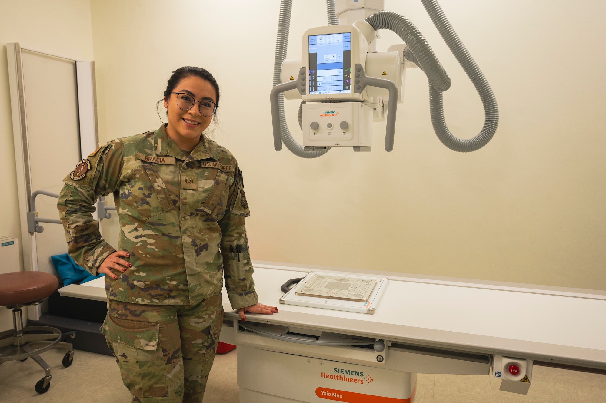 U.S. Air Force Staff Sgt. Kimberly Gracia, 8th Health Care Operations Squadron diagnostics & therapeutics non-commissioned officer in charge, poses for a photo next to an x-ray machine.