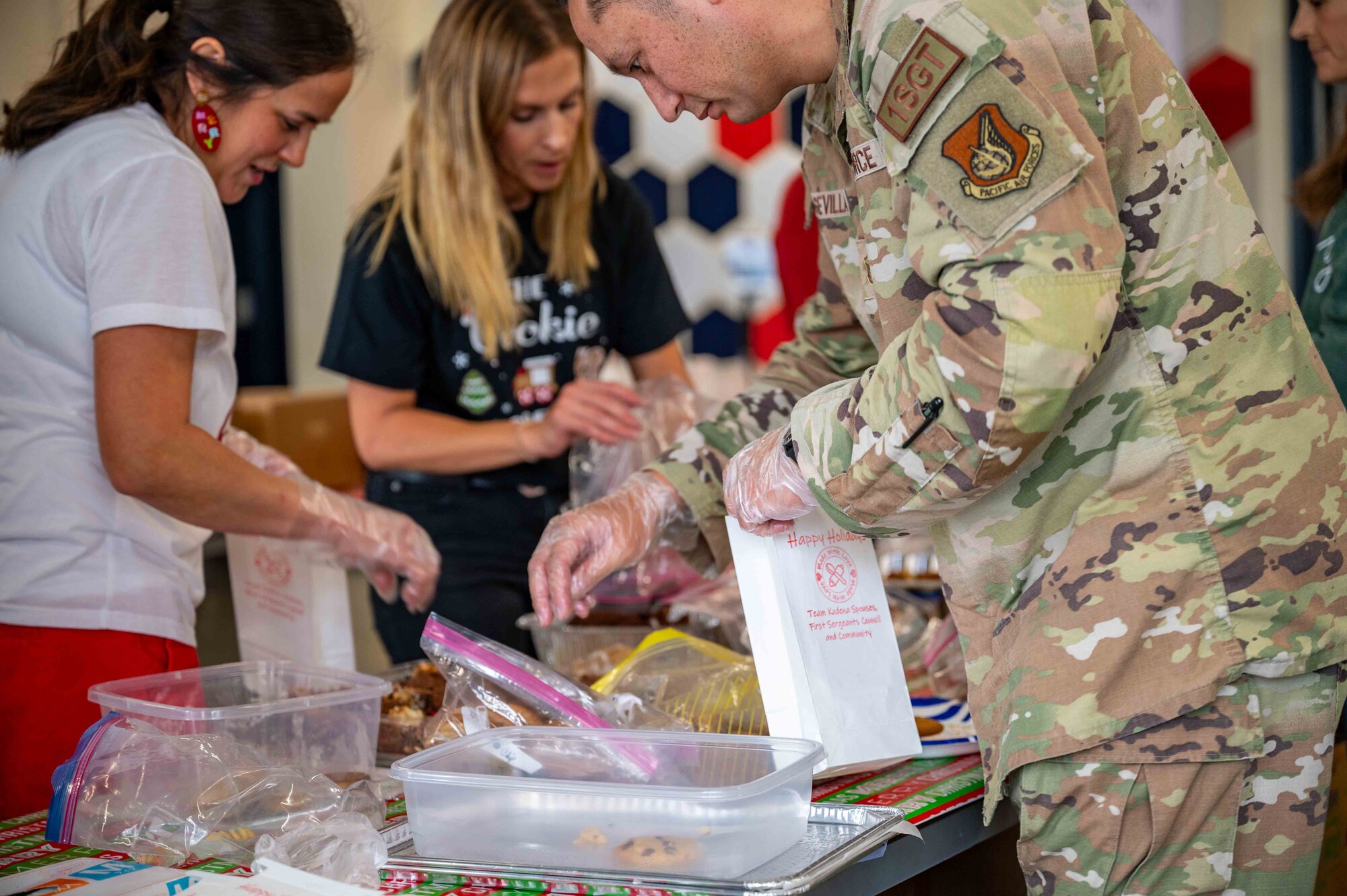 military members packs a bag with cookies