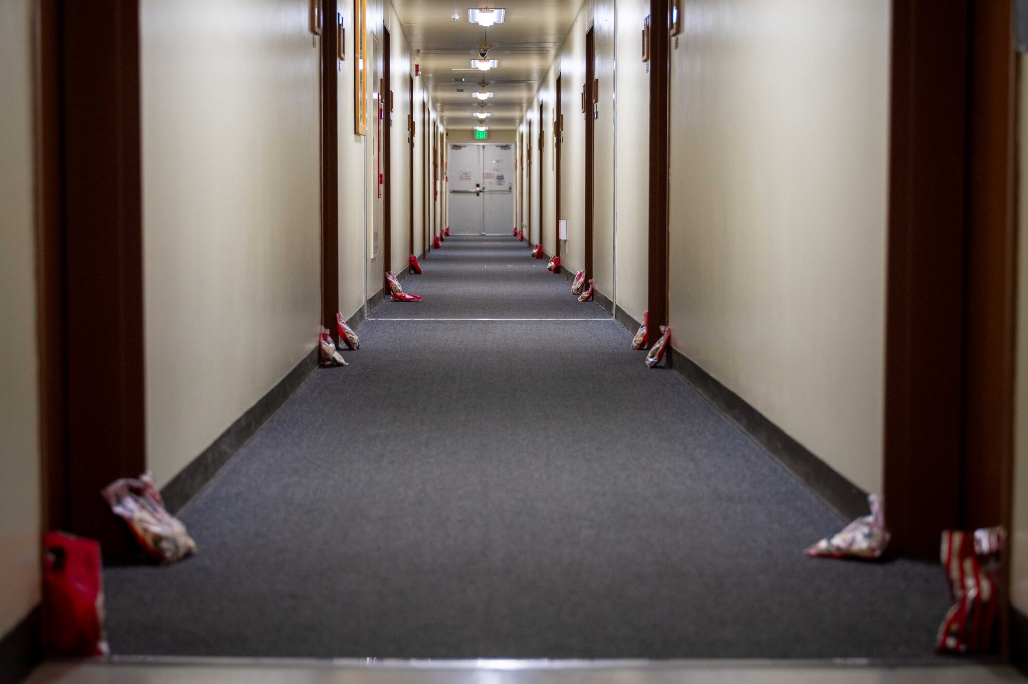bags of cookies placed in front of doors lined up down a dorm hallway