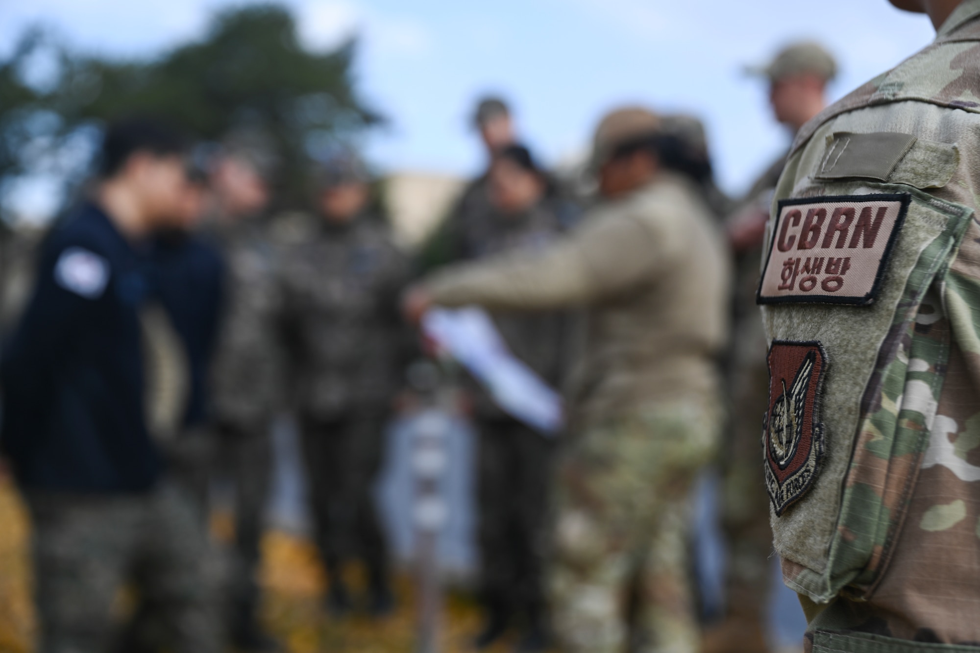 A Chemical, Biological, Radiological, Nuclear patch and Pacific Air Forces patch is displayed on Airman 1st Class Gabrielle Angylyka Fernandez, 8th Civil Engineer Squadron installation office of emergency management apprentice, during U.S. and Republic of Korea Air Force-partnered CBRN training at Kunsan Air Base