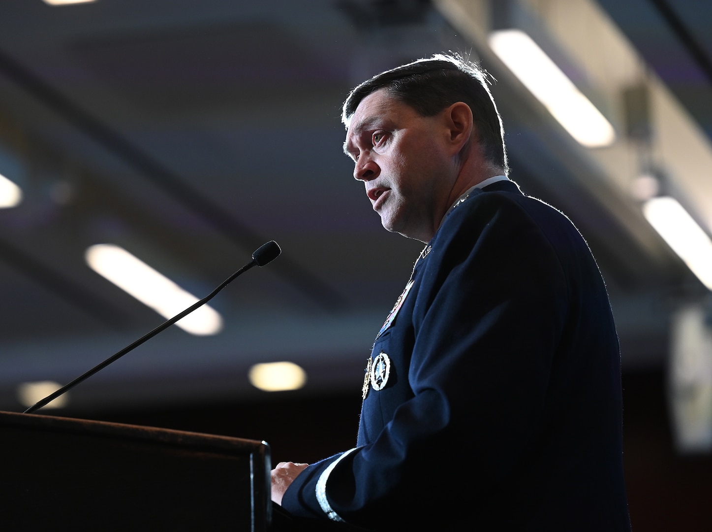 A military member speaks at a podium.
