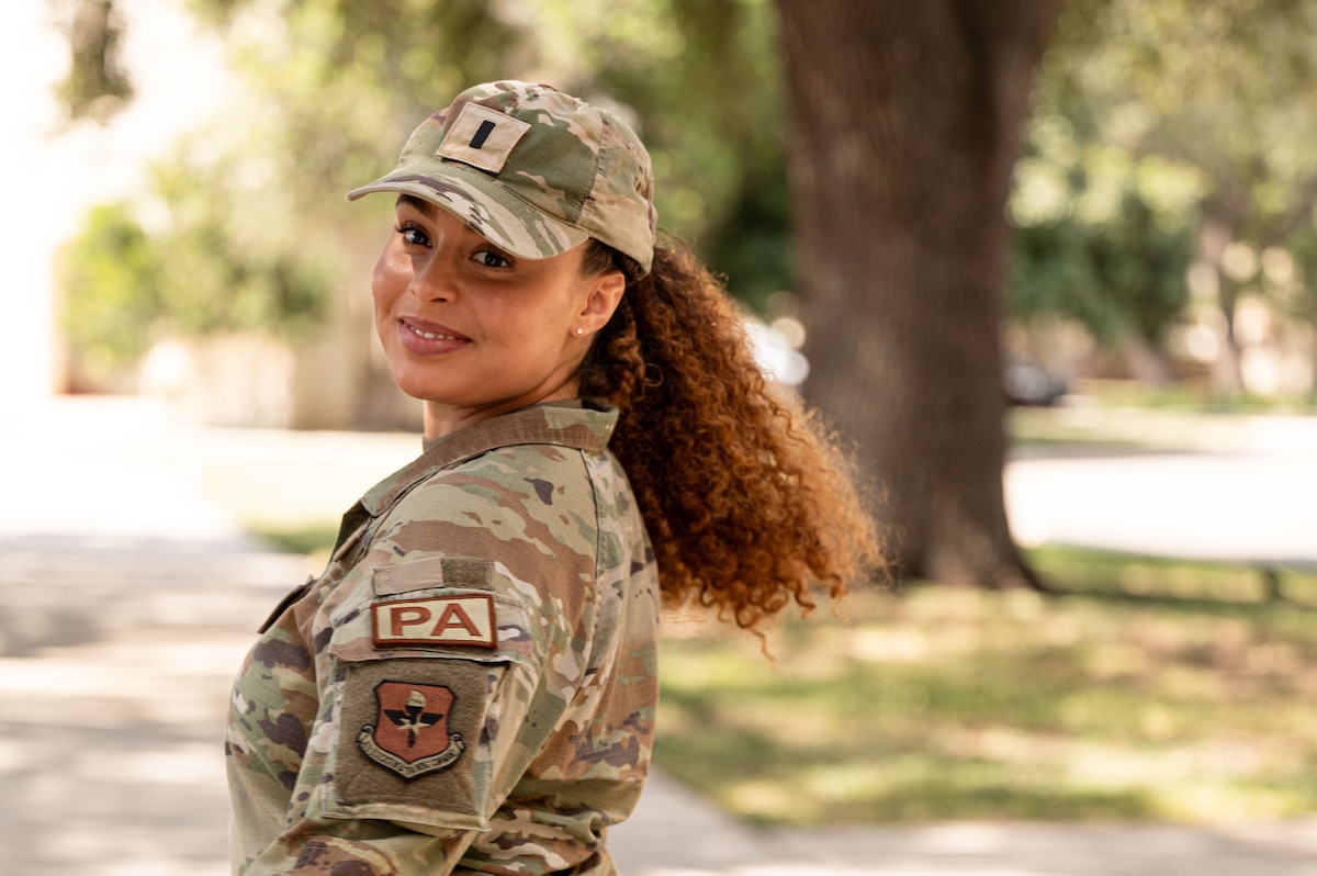 woman in uniform poses outside