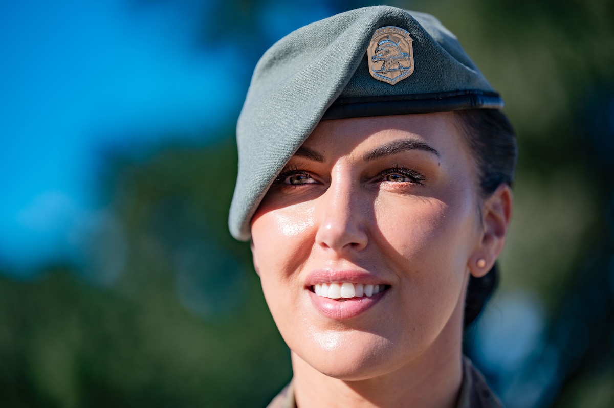 woman in uniform with sage beret smiles