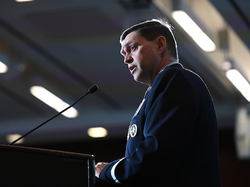 A military member speaks at a podium.