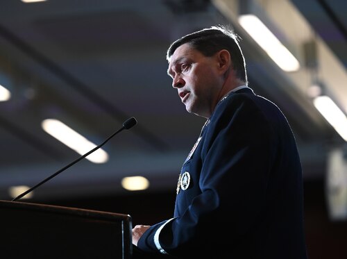 A military member speaks at a podium.