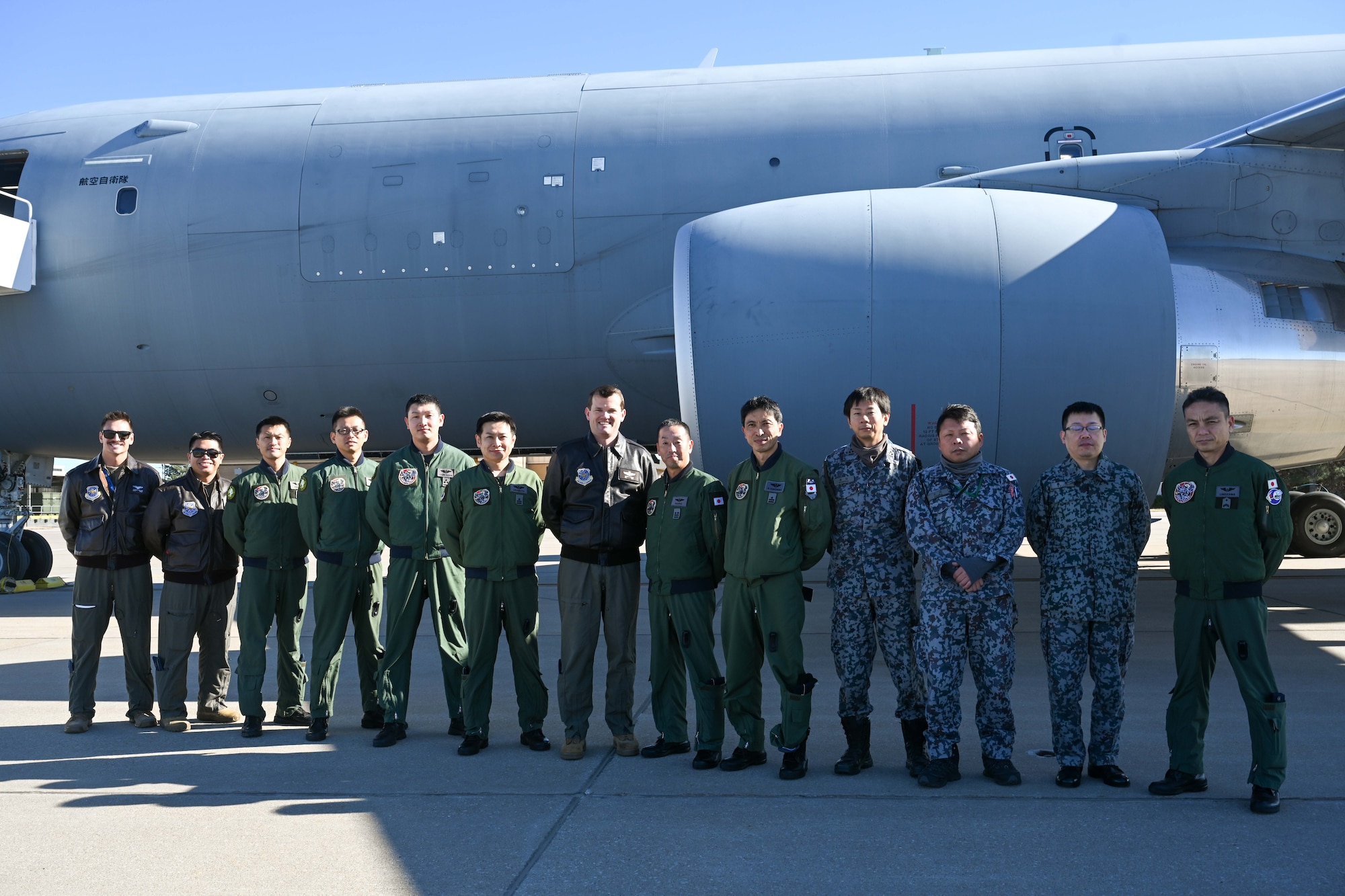 People group around to discuss operational capabilities relating to a KC-46 refueling airplane.