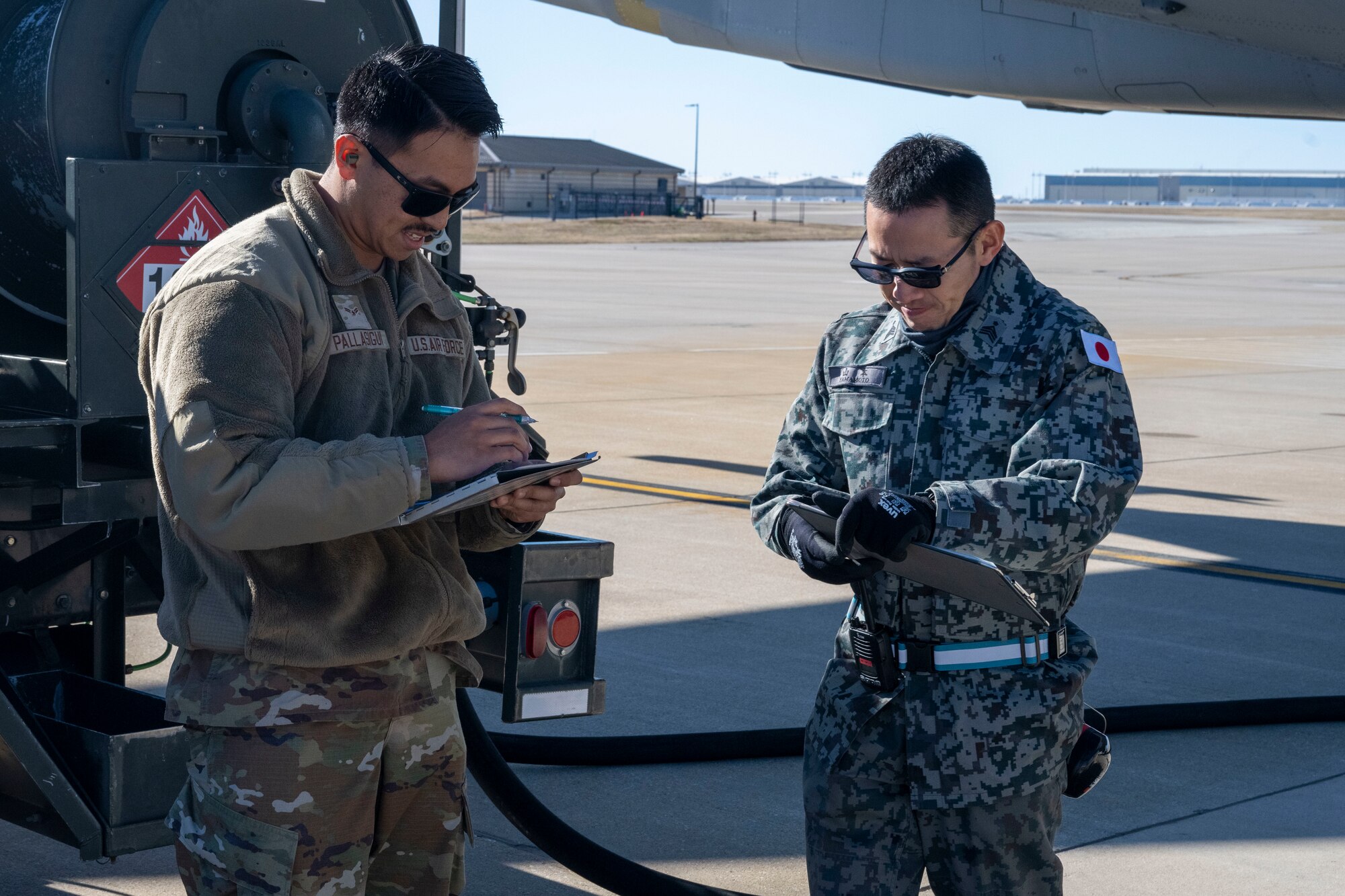 People group around to discuss operational capabilities relating to a KC-46 refueling airplane.