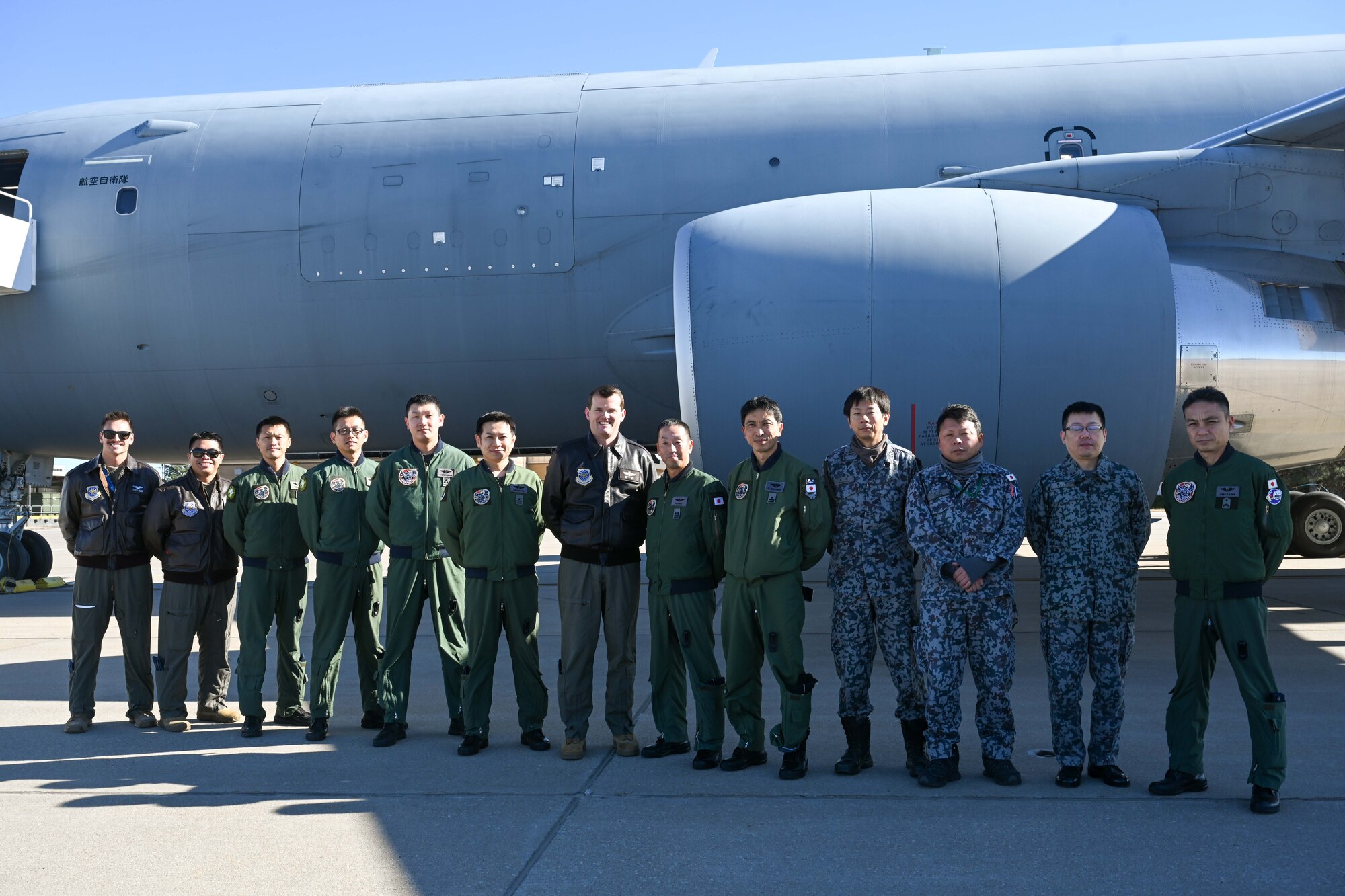 People group around to discuss operational capabilities relating to a KC-46 refueling airplane.