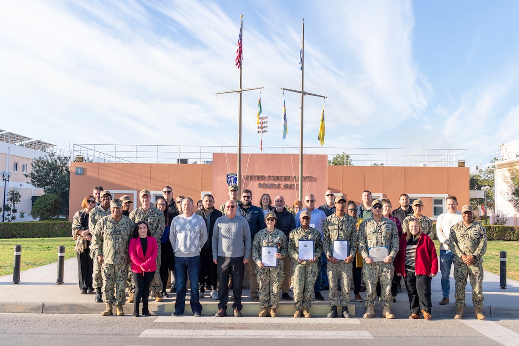 Personnel from Naval Supply Systems Command (NAVSUP) Fleet Logistics Center (FLC) Sigonella, and NAVSUP FLC Sigonella, Site Souda Bay, pose for a group photo following an award ceremony onboard Naval Support Activity (NSA) Souda Bay, Crete, Greece, Dec. 12, 2024.