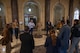 A group of civilians and service members conversing in a hallway of the Capitol building