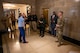 A group of civilians and service members conversing in a hallway of the Capitol building