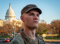 An Airman looking off into the distance with the U.S. Capitol building in the background