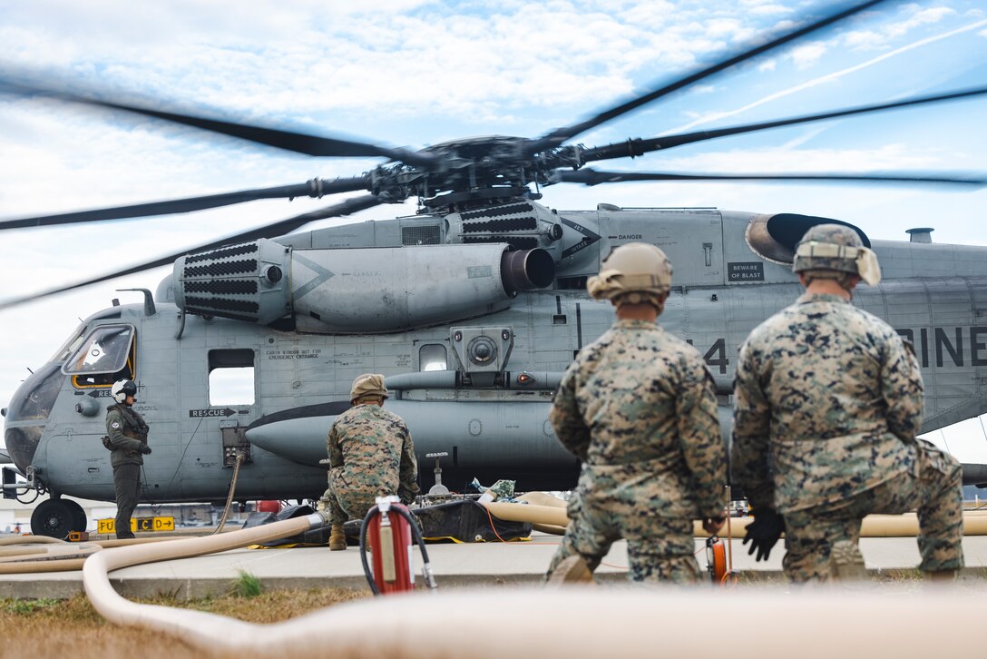 U.S. Marines with 8th Engineer Support Battalion, Combat Logistics Regiment 27, 2nd Marine Logistics Group, and Marine Heavy Helicopter Squadron 464, 2nd Marine Air Wing, observe a CH-53E Super Stallion receive fuel during bulk refuel operations on Marine Corps Air Station New River, North Carolina, Dec. 11, 2024. The 8th ESB Expeditionary fuel technicians conducted the exercise to train Marines on how to use an Expeditionary Fuel Dispensing System-Small, to improve operational refuel missions in a controlled training environment. (U.S. Marine Corps photo by Sgt. Mary Torres)