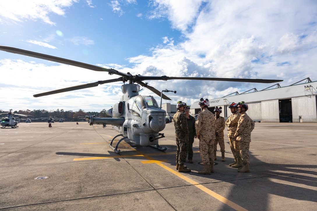 U.S. Marine Corps Chief Warrant Officer 2 Eric Thurau, left, from Florida and an aviation ordnance officer, and Master Sgt. Michael Raines, from Indiana and an aviation ordnance chief, both with Marine Light Attack Helicopter Squadron (HMLA) 167, speak with Royal Bahraini Air Force personnel at Marine Corps Air Station New River, North Carolina, Dec. 10, 2024. HMLA-167 welcomed members of the Royal Bahraini Air Force as part of a visit that allowed them to observe daily squadron operations, exchange best practices, and increase interoperability with U.S. Marine Corps light attack helicopter units. (U.S. Marine Corps photo by Sgt. Christopher Hernandez)