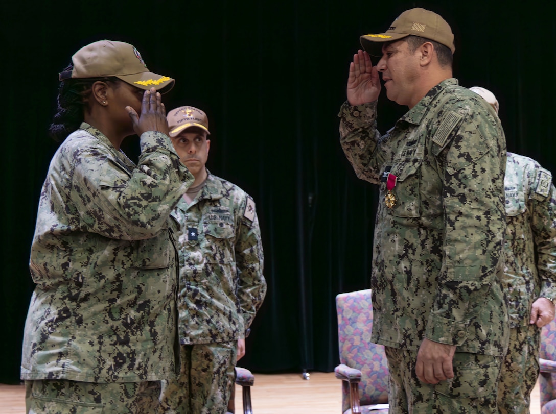 U.S. Navy Capt. Cherie Taylor, incoming commander of Task Force (TF) 53, left, relieves Capt. Christopher K. Brusca, outgoing commander of TF 53, during a change of command ceremony onboard Naval Support Activity Bahrain.