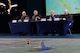 A group of service members lined up at a table responding to media questions from out of frame