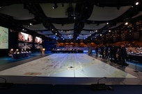 media is lined up on the right side with a table of service members on stage ready for questions