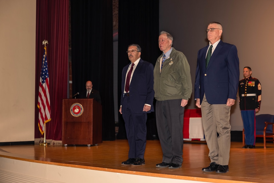 From left, Sgt. Domenic Ferlaino, Capt. Kevin Jarvis and Maj. Warren Kyle, all retired U.S. Marines formerly assigned to Marine Security Guard Detachment Cameroon stand at attention during an award ceremony at Little Hall on Marine Corps Base Quantico, Virginia, Dec. 13, 2024. The former Detachment Cameroon Marines attended the Marine Security Guard graduation ceremony to receive certificates of Commendation for their heroic actions taken during 1977 while rescuing an aide employee from marauders. (U.S. Marine Corps photo by Cpl. Darien Wright)