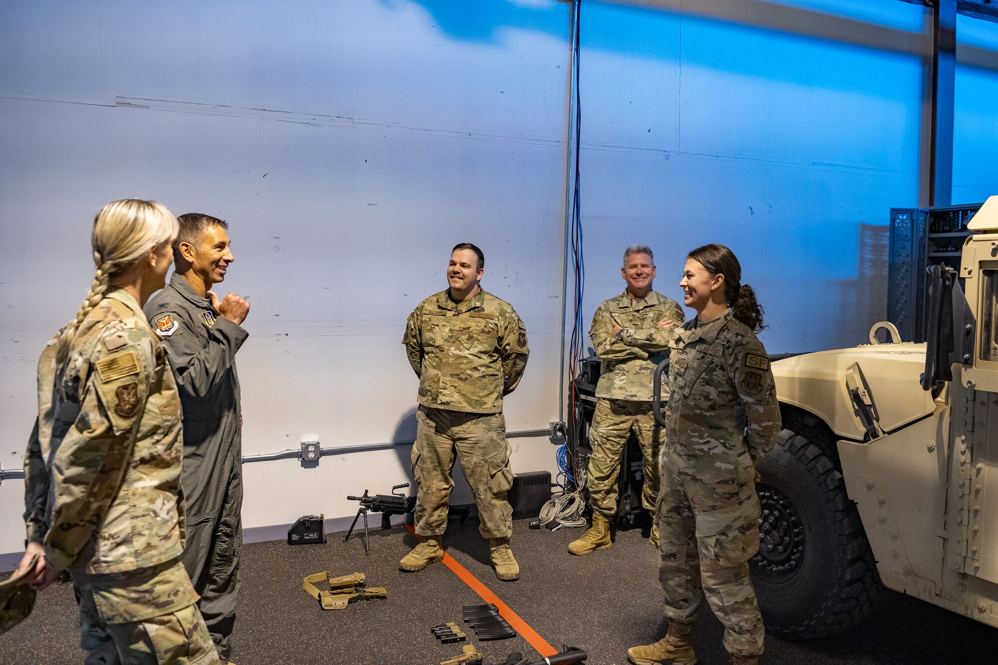 A group of uniformed service members talk to each other standing in a circle.