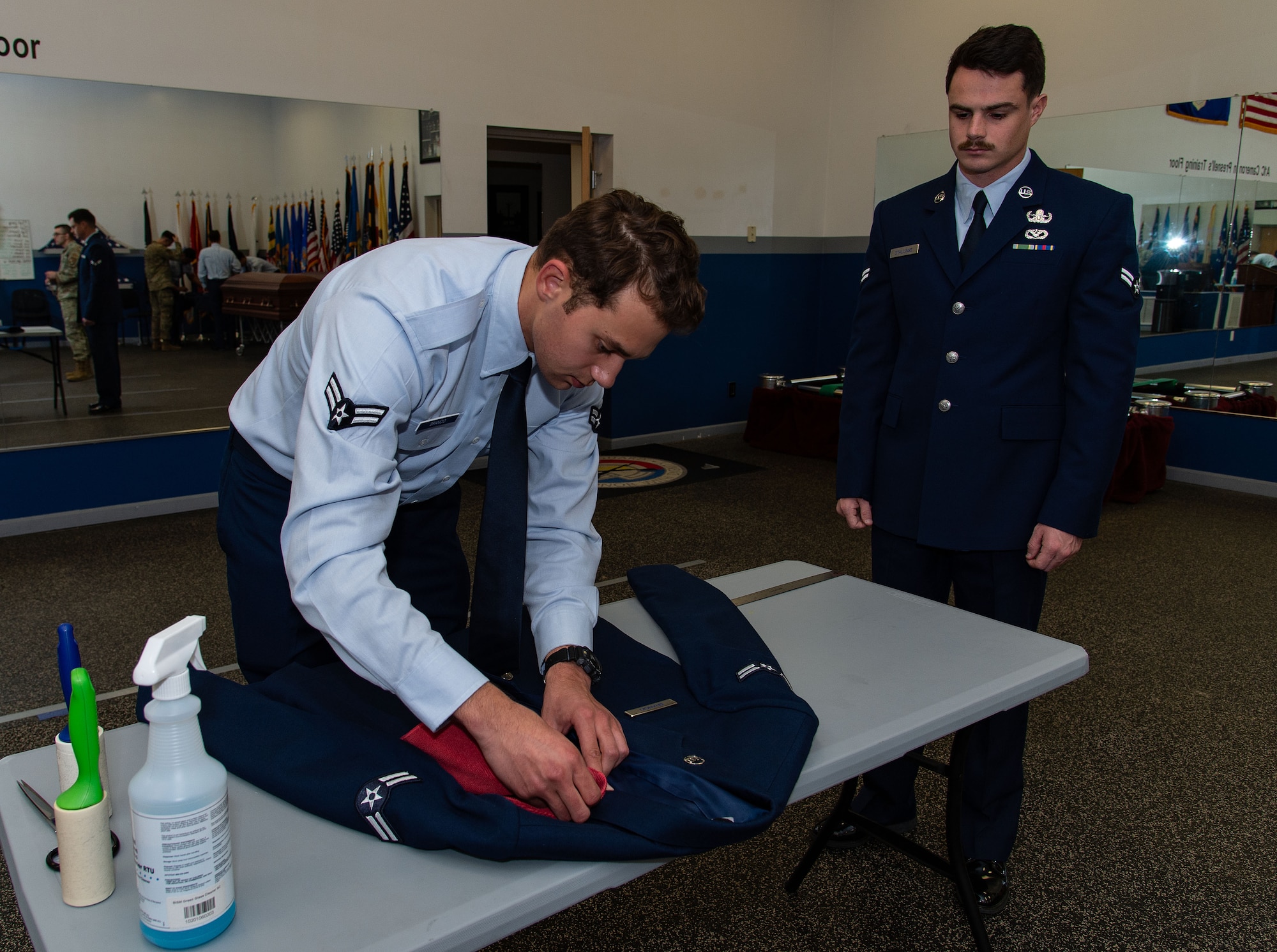 U.S. Airman 1st Class Carter Stallings, right, watches Airman 1st Class Kenneth Brancio, left, both 436th Civil Engineer Squadron explosive ordnance disposal apprentices, prepare his service dress coat for inspection during the Below-The-Zone Prep Course on Dover Air Force Base, Delaware, Nov. 14, 2024. Dover Base Honor Guard instructors held a two-day prep course designed for Airmen to sharpen their skills and prepare them for the BTZ selection board process. (U.S. Air Force photo by Roland Balik)