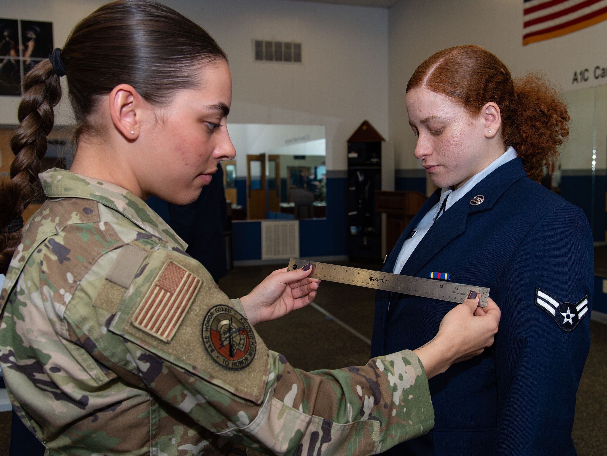 U.S. Air Force Senior Airman Sierra Davenport, Dover Base Honor Guard member, inspects the placement of ribbons on Airman 1st Class Kathiana Campos Torres, 436th Mission Generation Group time change items monitor, during the Below-The-Zone Prep Course on Dover Air Force Base, Delaware, Nov. 14, 2024. Fourteen BTZ-eligible candidates received nine hours of hands-on board practice plus 10 hours of curriculum focused on professional presentation, public speaking, and dress and appearance applications. (U.S. Air Force photo by Roland Balik)