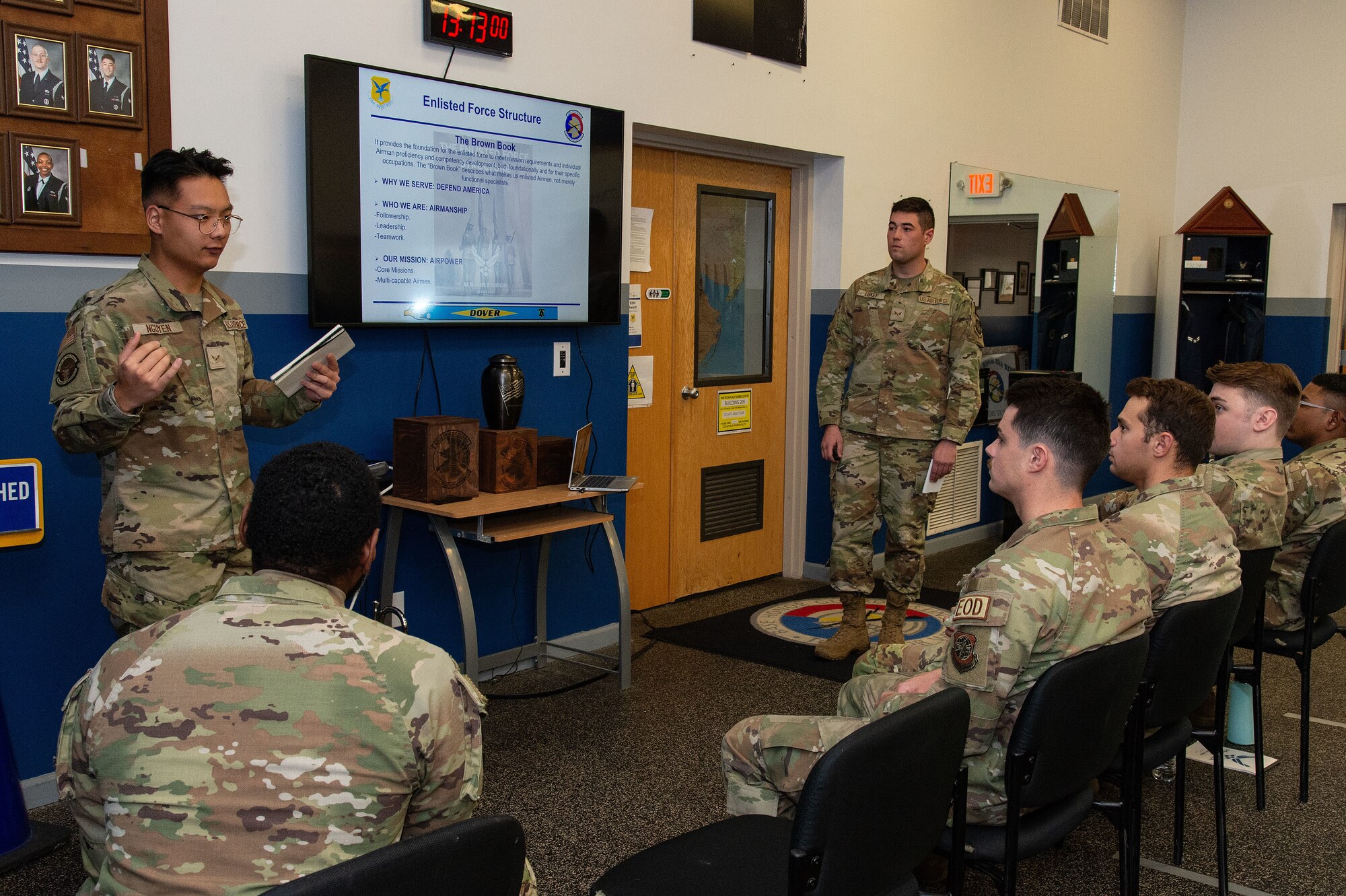 U.S. Airman 1st Class William Nguyen, left, along with Senior Airman Scott Liskey, right, both Dover Base Honor Guard members, brief Airmen about the Enlisted Force Structure during the Below-The-Zone Prep Course on Dover Air Force Base, Delaware, Nov. 14, 2024. Dover Base Honor Guard instructors held a two-day prep course designed for Airmen to sharpen their skills and prepare them for the BTZ selection board process. (U.S. Air Force photo by Roland Balik)