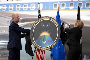 Two Airmen unveil an emblem.