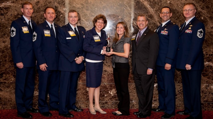 Chief Master Sgt. Brian L. Hale, Chief Master Sgt. Michael T. Woelfle, Capt. Jack Scoda, Ms. Jane White, Ms. Jaime Jones, Dr. Harold Arata, Maj. George Galloway and Senior Master Sgt. Michael Wabiszewski pose for a group photo.