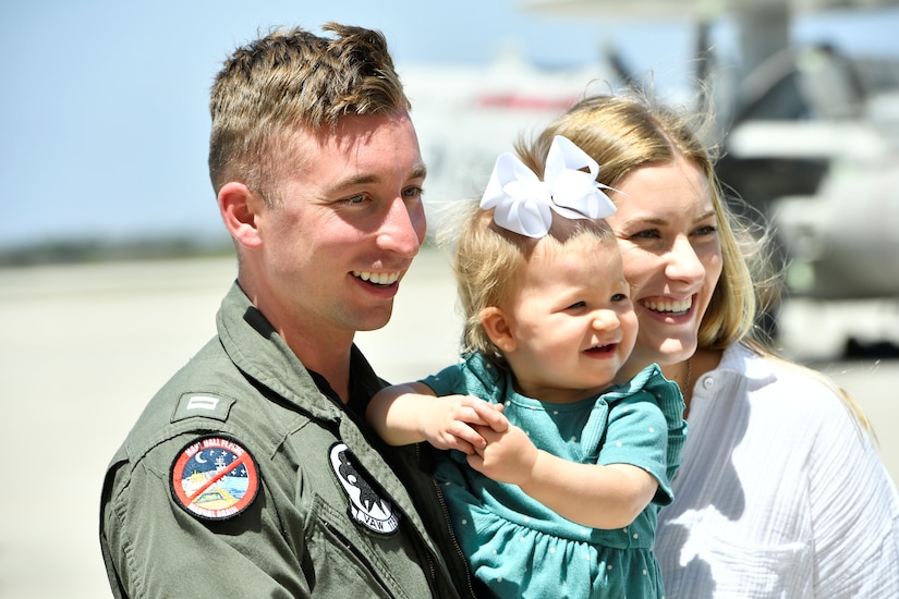 Man and woman holding a baby and smiling