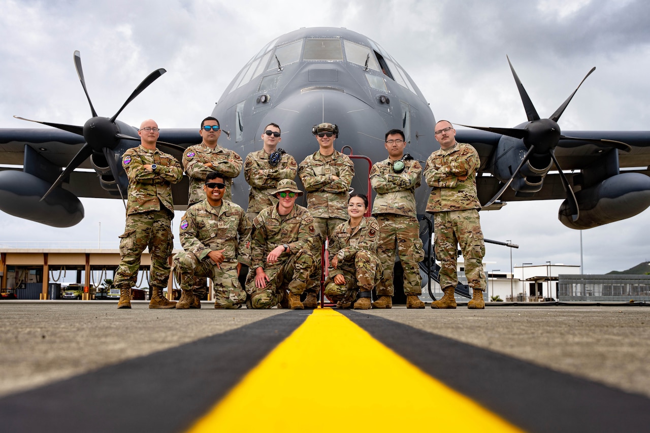 Airmen pose in front of their heavily armed aircraft before launching from a Hawaiian airfield.