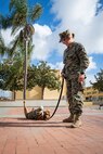 U.S. Marine Corps Combat Photographer and Mascot Handler, Cpl. Sarah Grawcock, with Headquarters and Service Battalion, Marine Corps Recruit Depot San Diego, and Lance Cpl. Bruno, the MCRD San Diego and Western Recruiting Region mascot give a presentation of the Depot mascot to students with the John F. Kennedy High School Marine Corps Junior ROTC program at Marine Corps Recruit Depot San Diego, Dec. 12, 2024. The mascot’s job is to boost morale, participate in outreach work and attend events and ceremonies. (U.S. Marine Corps photo by Cpl. Francisco Angel)